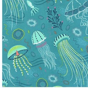 May include: A teal blue fabric with a repeating pattern of jellyfish, seaweed, and other sea life. The jellyfish are in various shades of blue and green, with long, flowing tentacles.
