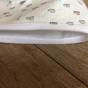 Pu&ograve; includere: Una pochette bianca con cerniera e fodera bianca. Il tessuto ha un motivo a griglia ed &egrave; decorato con un motivo ripetitivo di piccole lumache disegnate a mano.