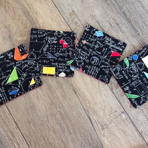 May include: Four black and white coasters with a red border. The coasters feature a variety of geometric shapes and mathematical equations. The text on the coasters includes "Multiplication", "Inter Rules", and "Total surface".