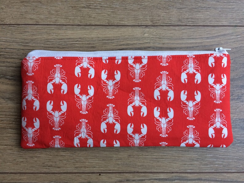 May include: Red zippered pouch with a white lobster pattern.
