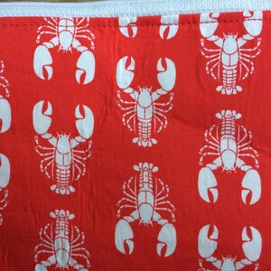 May include: Red fabric with a white repeating pattern of lobsters.