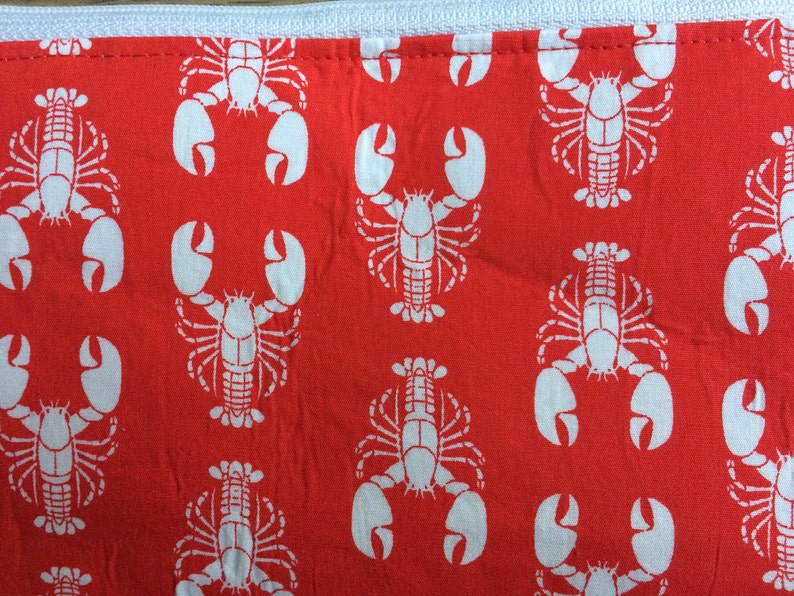 May include: Red fabric with a white repeating pattern of lobsters.