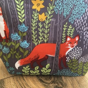 May include: A gray fabric tote bag with a repeating pattern of orange foxes, green leaves, and blue flowers.