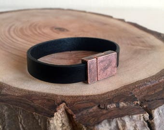 May include: A black leather bracelet with a copper magnetic clasp.