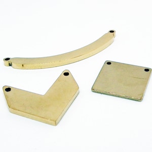 Peut inclure: Trois pièces en métal doré avec des trous pour la fixation de bijoux. Les pièces sont une barre incurvée, un carré et une forme de chevron.