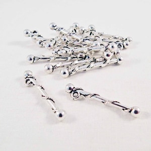 Peut inclure: Un tas de embouts de perles en métal argenté avec un design torsadé. Les embouts de perles mesurent environ 2,5 cm de long et ont une perle ronde à chaque extrémité.