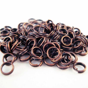 Puede incluir: Un montón de anillas de salto de cobre, un tipo de hallazgo de joyería utilizado para conectar cadenas, cordones y otros componentes de joyería.