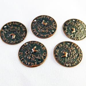 May include: Five antique-looking copper-coloured metal coins with raised lettering and images. The coins have a dark green patina and are arranged in a circle on a white surface.
