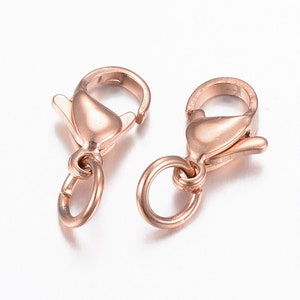 Peut inclure: Deux fermoirs à ressort en or rose avec un anneau de saut. Ces fermoirs sont utilisés pour la fabrication de bijoux.