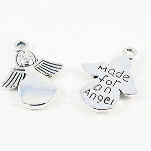 May include: Two silver angel charms. One charm features a detailed angel with wings and the other charm has the words "Made for an Angel" engraved on it.
