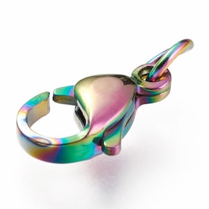 May include: A rainbow-colored metal clasp with a spring-loaded closure. The clasp is designed for attaching jewelry or other items.