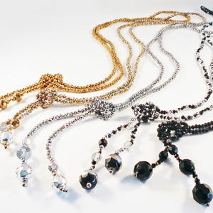 May include: Four beaded necklaces with different coloured beads and tassel ends. The necklaces are gold, silver, and black.