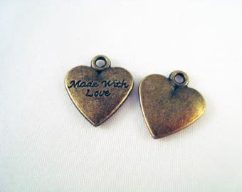 May include: Two antique gold heart-shaped charms. One charm has the words "Made With Love" inscribed on it.