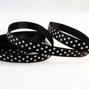 May include: Black and white polka dot ribbon. The ribbon is made of a satin material and has a smooth texture.