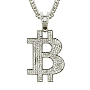 Può includere: Collana color argento con un grande ciondolo a forma di simbolo Bitcoin. Il ciondolo è incastonato con numerosi piccoli cristalli trasparenti, creando un effetto scintillante. La catena è a maglia spessa.