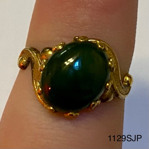 Gold colored ring with medium sized jade colored stone