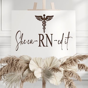 May include: A white sign with a brown medical caduceus symbol and the text "She ca-RN-ed it".