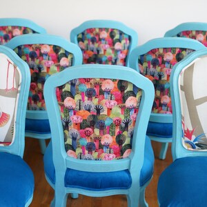 May include: Six turquoise blue chairs with different colorful patterned fabric upholstery. The chairs have a classic design with a curved back and a blue velvet seat.