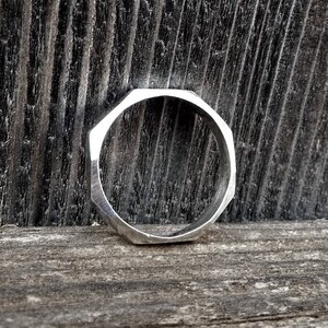 May include: A silver octagonal ring with a smooth, polished finish.