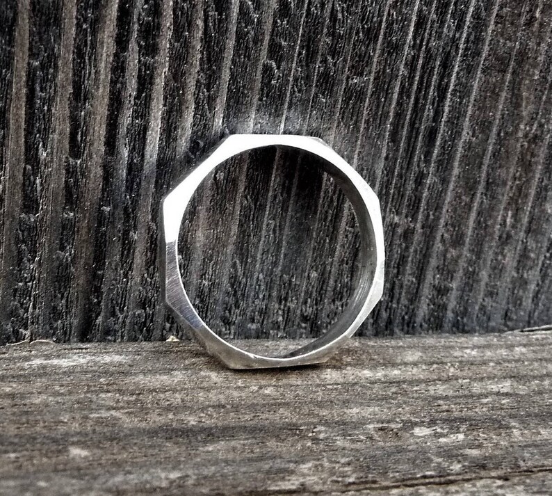 May include: A silver octagonal ring with a smooth, polished finish.