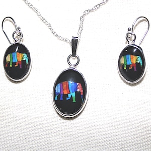 May include: A silver necklace and earrings set featuring a colorful mosaic elephant design on black oval pendants.