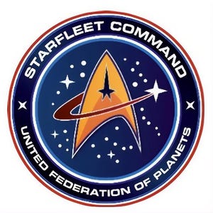 May include: Circular emblem featuring the Starfleet Command logo. The design includes a gold and orange delta shape with a red arc, a star, and the text "STARFLEET COMMAND" and "UNITED FEDERATION OF PLANETS" in white lettering on a blue background.