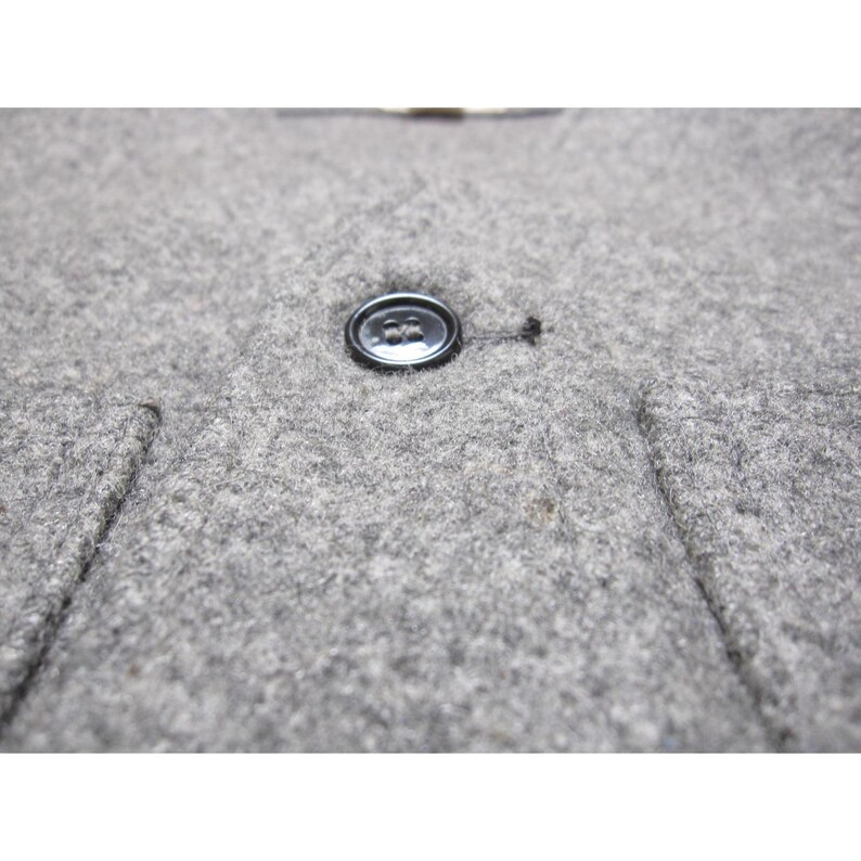 Puede incluir: Una taza de cer&aacute;mica blanca con un asa negra y el texto "But First, Coffee" en negrita negra. La taza est&aacute; sobre un fondo borroso. La taza mide aproximadamente 10 cm de altura.