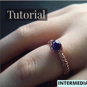 May include: A copper wire ring with a dark blue gemstone. The ring is on a person's finger. The image is labeled "Tutorial" and "INTERMEDIATE".