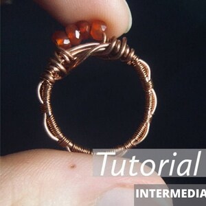 May include: A copper wire ring with a cluster of orange carnelian stones at the top. The ring is on a finger and the word "Tutorial" is written in white on a gray background. The word "INTERMEDIATE" is written in white on a black background.