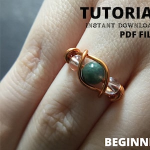 May include: A copper wire ring with a green stone and clear and pink beads. The ring is on a person's finger. The image has the text "TUTORIAL INSTANT DOWNLOAD PDF FILE BEGINNER".