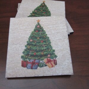 May include: Set of four wooden coasters featuring a Christmas tree with ornaments and presents. The coasters have a rustic, wood-grain texture.