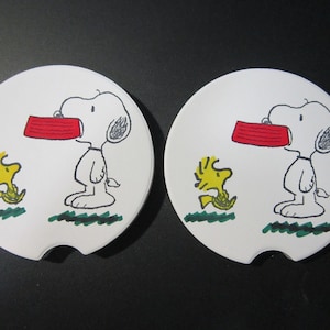 Set of 2 Snoopy & Woodstock car coasters for your cup holders. Featuring the fun loving Peanuts dog and his little buddy.