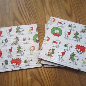 Set of 4 vinyl plank coasters w/ images of Snoopy decked out for Christmas! With a wreath, tree, lights, and skating...lots of Holiday fun!