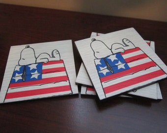 Set of 4 vinyl plank coasters w/ images of Snoopy on his dog house, painted like an American flag!  Adorable Peanuts patriotic display!