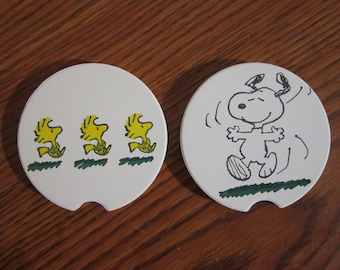 Set of 2 Snoopy & Woodstock car coasters for your cup holders. Featuring the fun loving Peanuts dog and buddy bird.