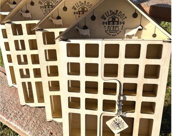 May include: Three wooden advent calendars shaped like houses with a Wild Root Acres logo on the front. Each calendar has 24 numbered doors.