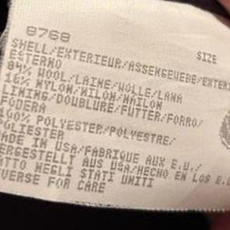 May include: A tag with the number 8768 and text in multiple languages, including "SHELL", "LINING", and "MADE IN USA". The tag lists the material composition as 84% wool and 16% nylon, with a 100% polyester lining.