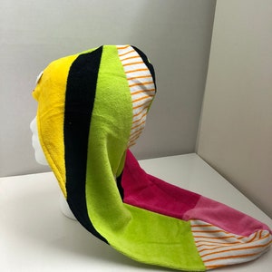 May include: A colorful hooded towel with stripes of yellow, black, green, pink, and white.