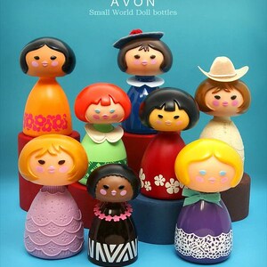 May include: A collection of eight colorful Avon Small World Doll bottles. The bottles are shaped like dolls with different hairstyles, clothing, and accessories. The bottles are arranged in a pyramid shape on a blue background.