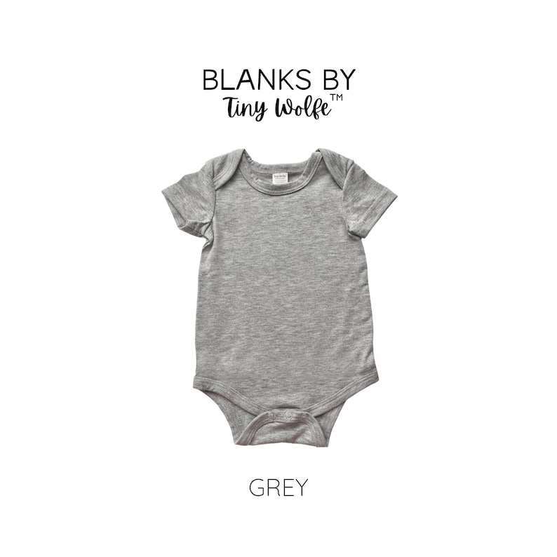 May include: Grey short-sleeved baby bodysuit with a crew neck. The bodysuit is blank and has the text "Blanks by Tiny Wolfe" above it.