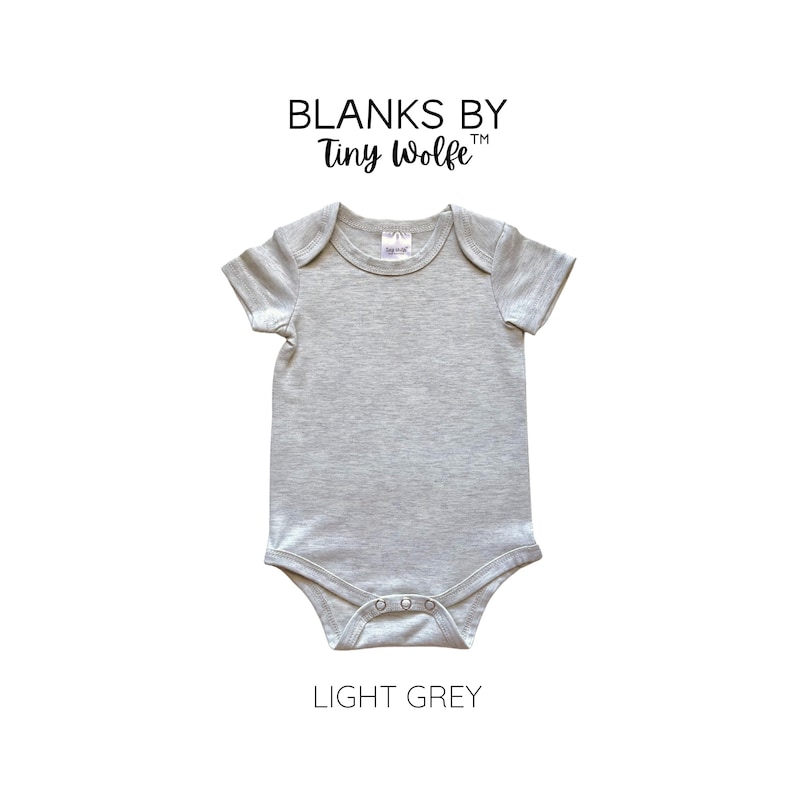 May include: Light grey baby onesie with short sleeves and a snap closure. The onesie is made of a soft, comfortable fabric and is perfect for everyday wear. Blanks by Tiny Wolfe.