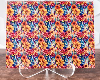 May include: A colorful floral print with a repeating pattern of orange, red, and blue flowers on a white background. The print is on a rectangular piece of paper.