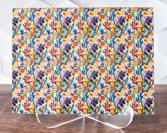 May include: A colorful floral print with yellow, blue, red, and orange flowers on a white background. The print is on a card that is standing on a clear acrylic stand.