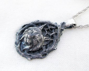 May include: A silver pendant necklace featuring a detailed, sculpted lynx head surrounded by a stylized, branching tree design.