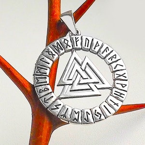May include: Silver pendant featuring a circular design with the Norse symbol Vegvisir in the center. The circle is made up of runes, the ancient alphabet of the Germanic peoples.