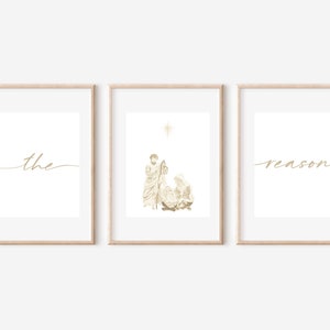 Puede incluir: Tres impresiones enmarcadas con un diseño de color dorado. La impresión de la izquierda dice "the" en cursiva. La impresión del medio muestra una escena de la Natividad con una estrella arriba. La impresión de la derecha dice "reason" en cursiva.
