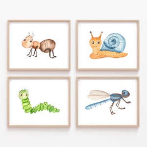 Puede incluir: Conjunto de cuatro ilustraciones de acuarela de insectos, que incluyen una hormiga, un caracol, una oruga y una libélula. Cada ilustración está enmarcada en un marco de madera claro y tiene un fondo blanco.