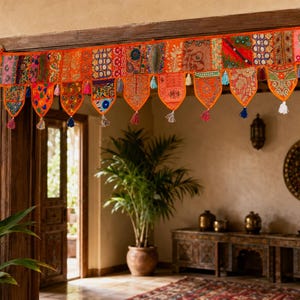 Peut inclure: Une cantonnière de porte rectangulaire en tissu présentant un patchwork vibrant de textiles brodés orange, rouges, roses et bleus. Le bord inférieur est fini avec plusieurs panneaux en forme de fanion, ornés de petites houppes.