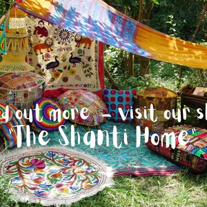 May include: A colorful bohemian-style seating area with patterned cushions, pillows, and a rug. The seating area is set up under a canopy made of a yellow and orange fabric. The text "Find out more - visit our shop 'The Shanti Home'" is visible in the image.