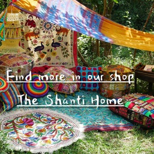 May include: A colorful bohemian-style seating area with patterned cushions, throw pillows, and a rug. The seating area is set up under a canopy made of fabric. The text "Find more in our shop The Shanti Home" is visible in the image.